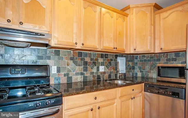 a kitchen with granite countertop a stove and a sink