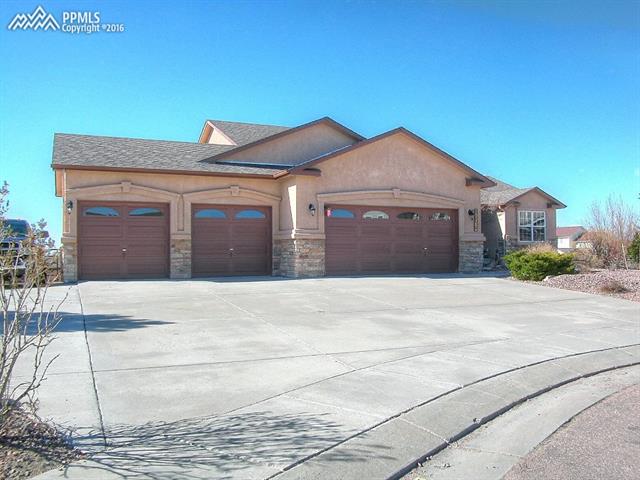 12153 Rio Secco Road Peyton, CO 80831 - Photo 2 of 26 Oversized 4 car garage with room for all of your toys! Additional paved parking on side of home.