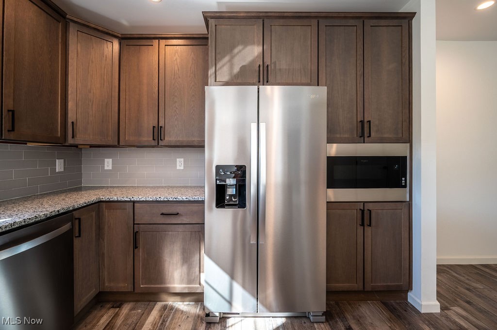 7343 Lost Pavement Road Belleville, WV 26133 - Photo 6 of 49 Kitchen featuring appliances with stainless steel finishes, light stone countertops, dark wood-style flooring, backsplash, and recessed lighting