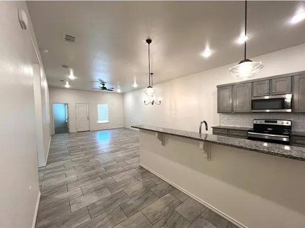 a large kitchen with stainless steel appliances a large counter top