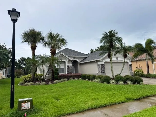 a front view of a house with a yard and potted plants