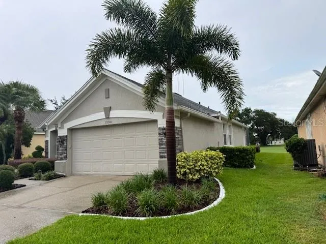 a front view of yellow house with a garden