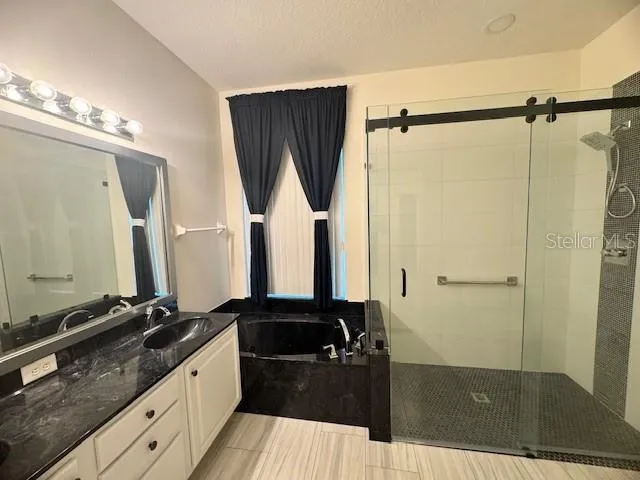 a bathroom with a granite countertop sink a mirror and shower