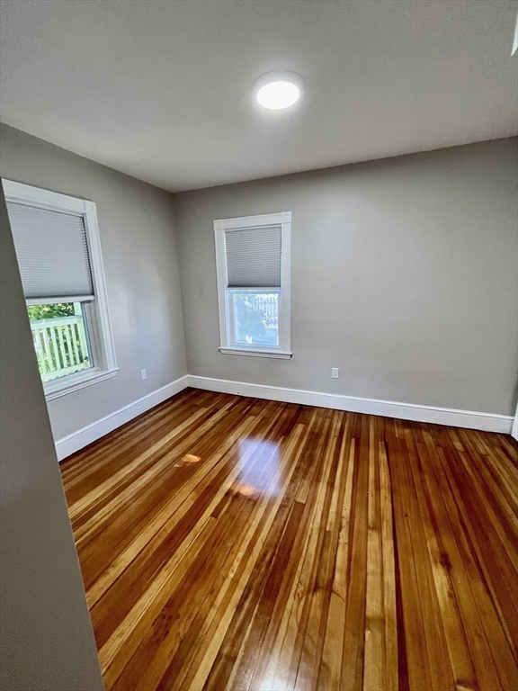24 Howes Street, Unit 3 Boston, MA 02125 - Photo 12 of 15 a view of an empty room with wooden floor and a window