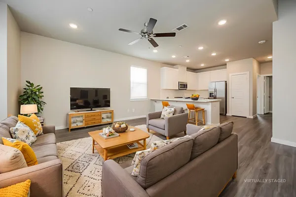 a living room with furniture kitchen view and a window