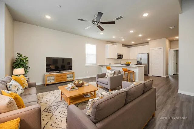 a living room with furniture kitchen view and a window