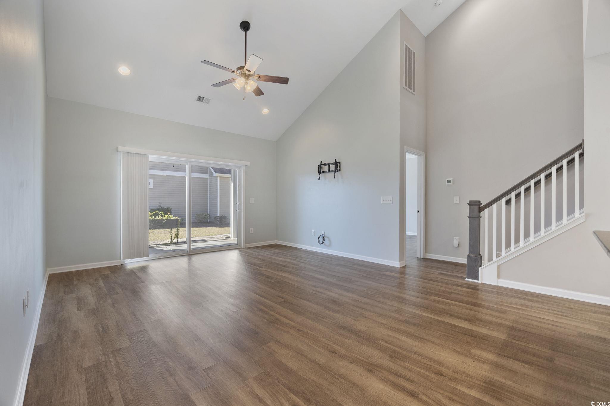 115 Machrie Loop, Unit D Myrtle Beach, SC 29588 - Photo 12 of 40 Unfurnished living room featuring high vaulted ceiling, wood finished floors, a ceiling fan, stairway, and recessed lighting