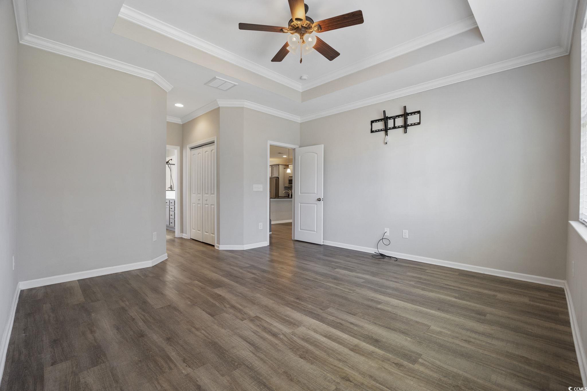 115 Machrie Loop, Unit D Myrtle Beach, SC 29588 - Photo 15 of 40 Unfurnished room featuring a tray ceiling, dark wood finished floors, a ceiling fan, and crown molding