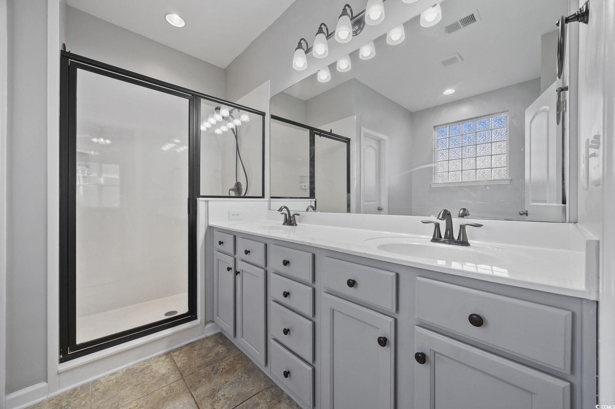 115 Machrie Loop, Unit D Myrtle Beach, SC 29588 - Photo 19 of 40 Full bath featuring double vanity, a shower stall, light tile patterned floors, and recessed lighting