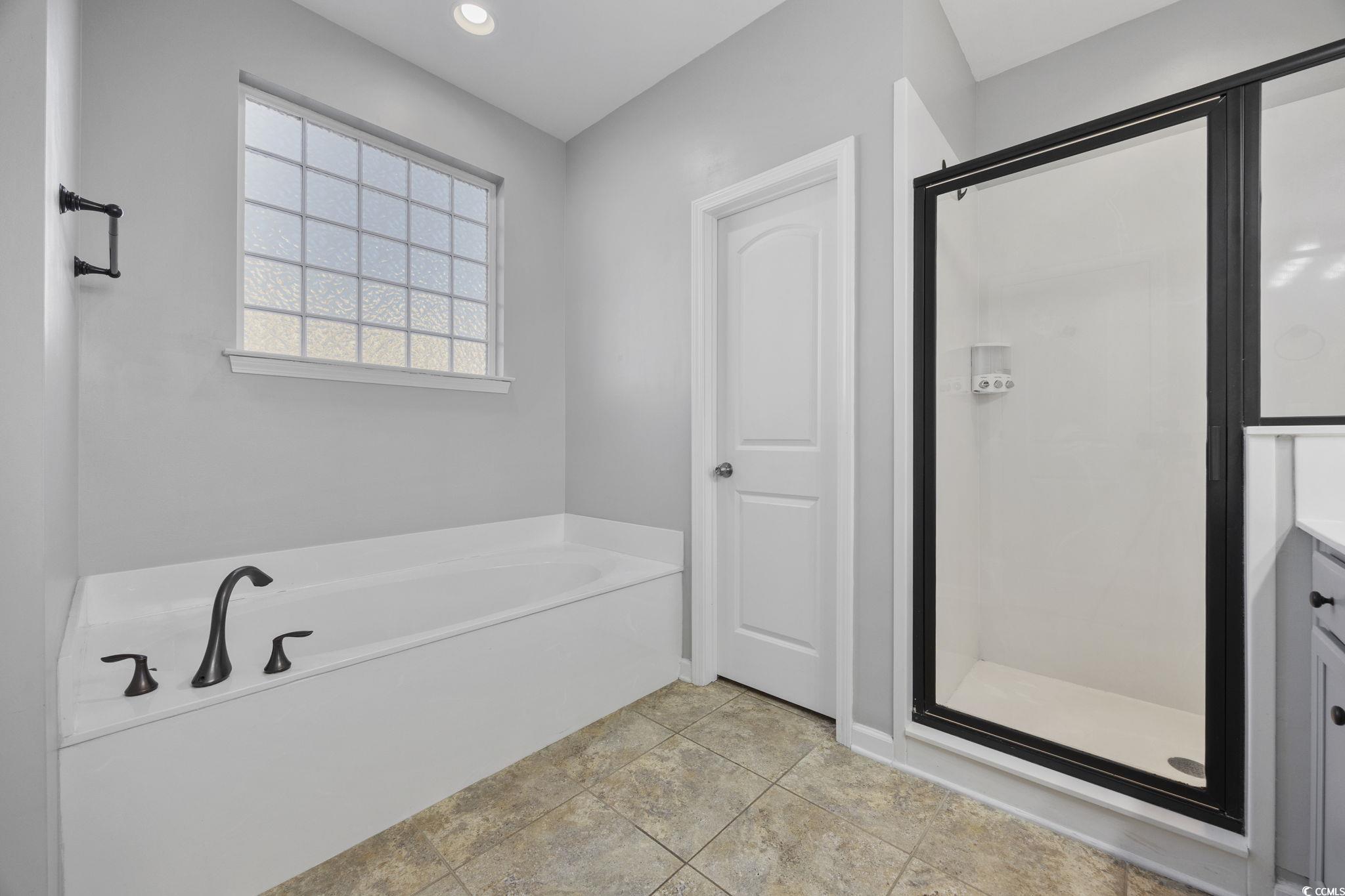 115 Machrie Loop, Unit D Myrtle Beach, SC 29588 - Photo 20 of 40 Bathroom with a stall shower, a bath, light tile patterned flooring, vanity, and recessed lighting