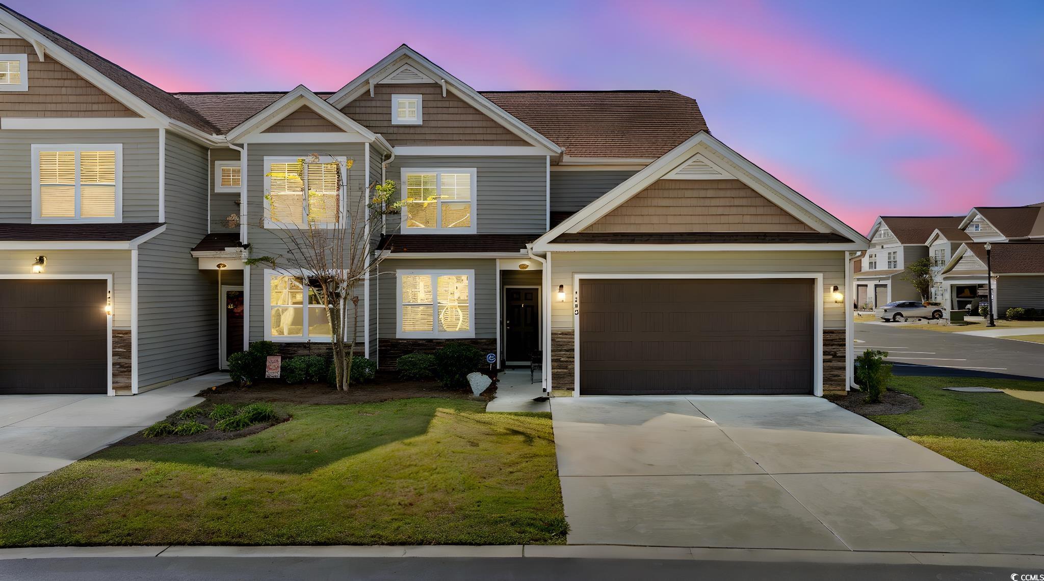 115 Machrie Loop, Unit D Myrtle Beach, SC 29588 - Photo 2 of 40 Craftsman house featuring stone siding, driveway, a yard, and a garage