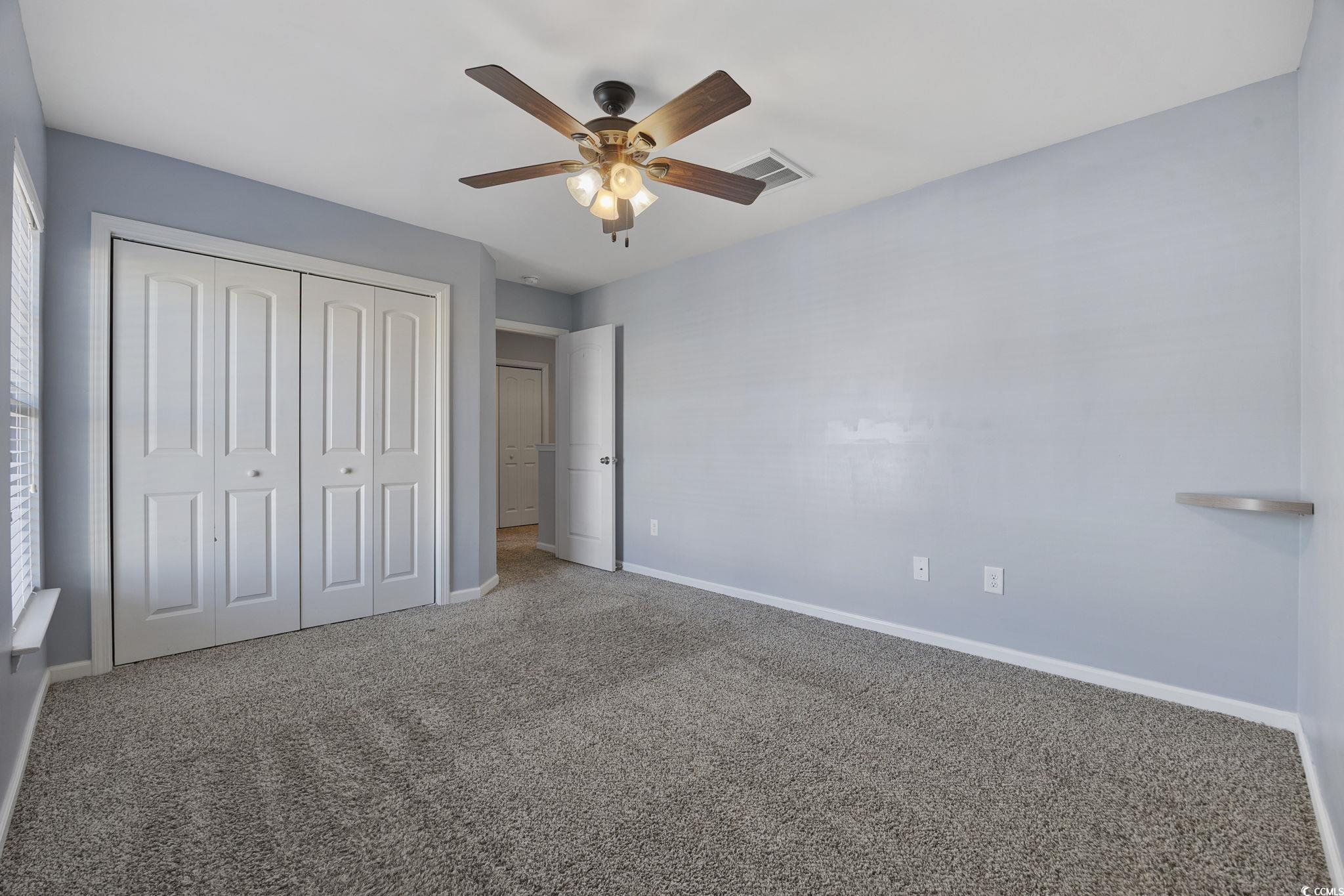 115 Machrie Loop, Unit D Myrtle Beach, SC 29588 - Photo 26 of 40 Unfurnished bedroom with carpet flooring, a closet, and ceiling fan