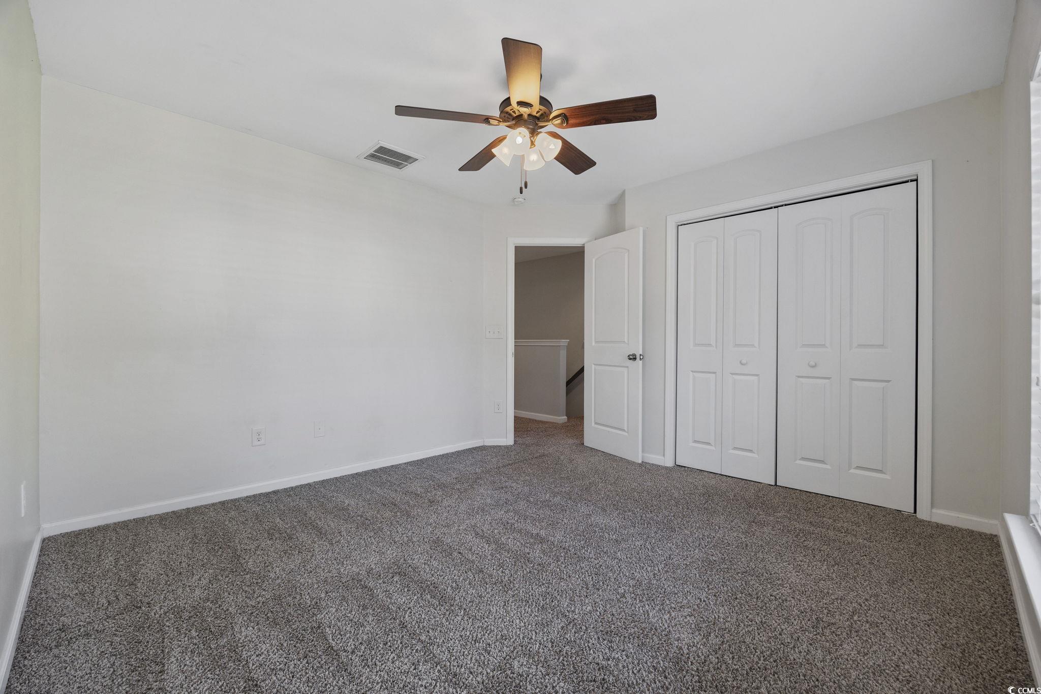 115 Machrie Loop, Unit D Myrtle Beach, SC 29588 - Photo 28 of 40 Unfurnished bedroom with a closet, carpet flooring, and ceiling fan