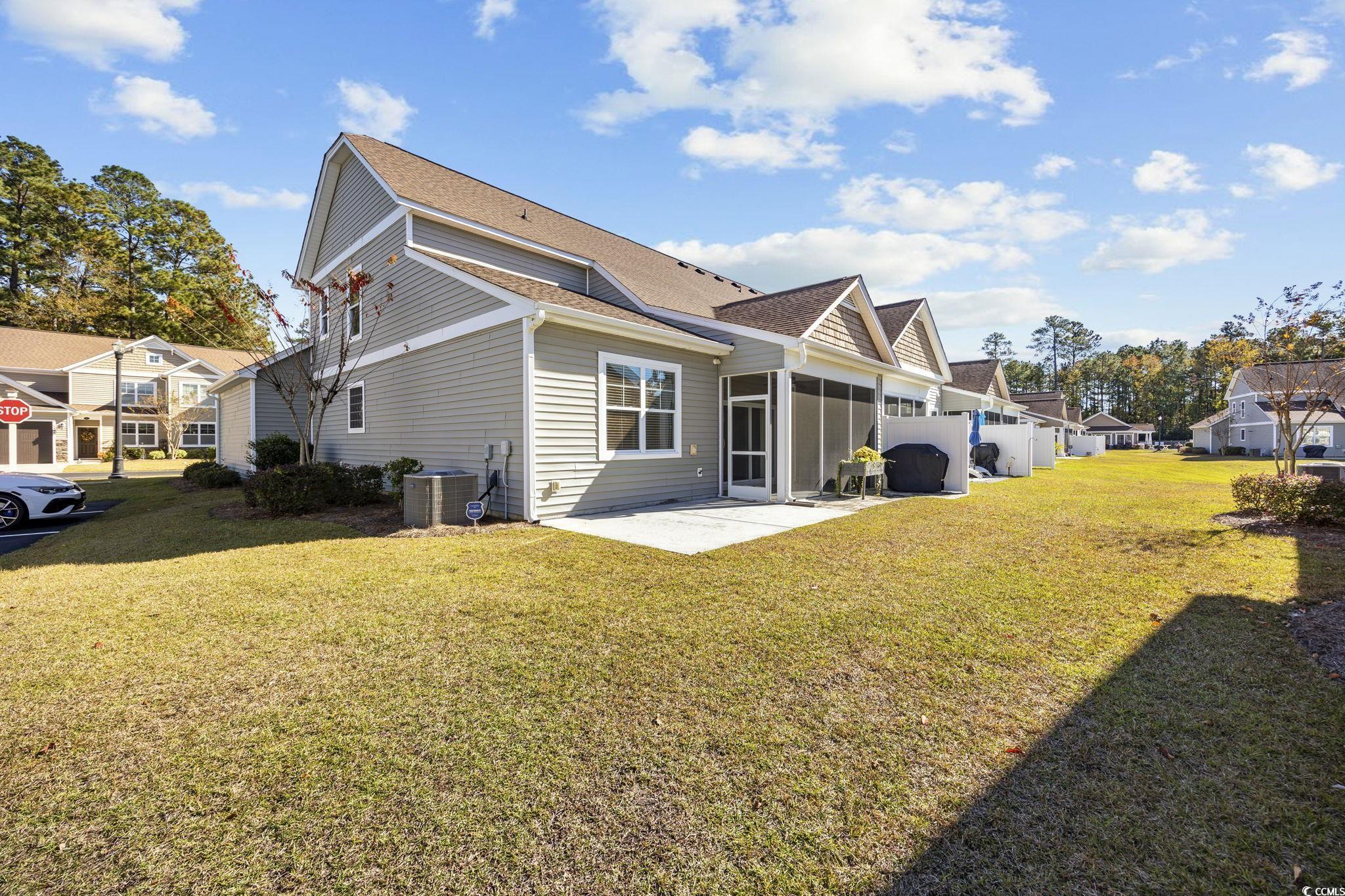 115 Machrie Loop, Unit D Myrtle Beach, SC 29588 - Photo 35 of 40 Rear view of house with roof with shingles, a patio, and a sunroom