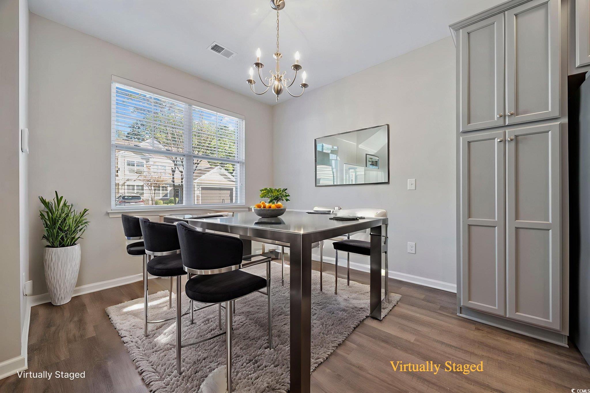 115 Machrie Loop, Unit D Myrtle Beach, SC 29588 - Photo 6 of 40 Dining space featuring dark wood-style flooring and a chandelier