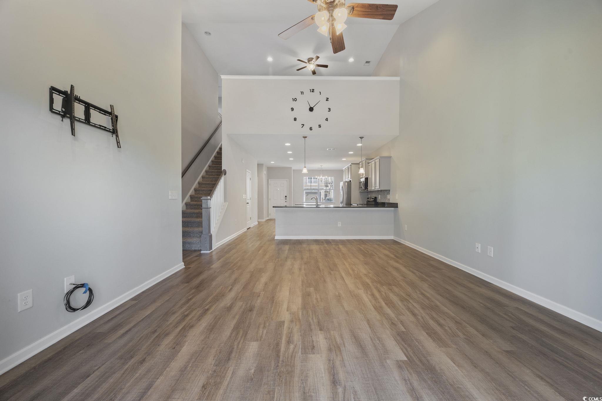 115 Machrie Loop, Unit D Myrtle Beach, SC 29588 - Photo 10 of 40 Unfurnished living room with dark wood finished floors, ceiling fan, high vaulted ceiling, stairway, and recessed lighting