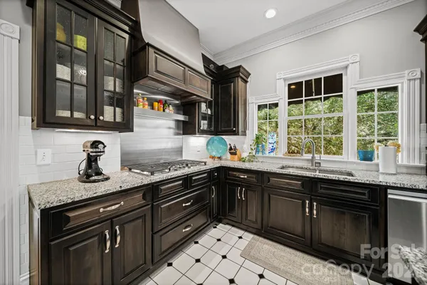 a kitchen with granite countertop stainless steel appliances stove and cabinets