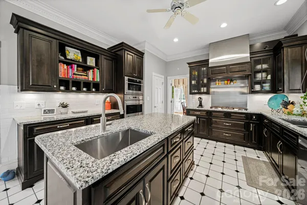 a kitchen with stainless steel appliances granite countertop a sink a stove and a refrigerator