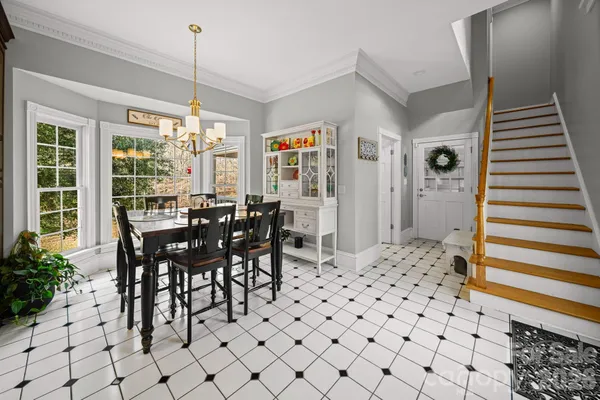 a kitchen with stainless steel appliances kitchen island granite countertop a stove a refrigerator a dining table and chairs