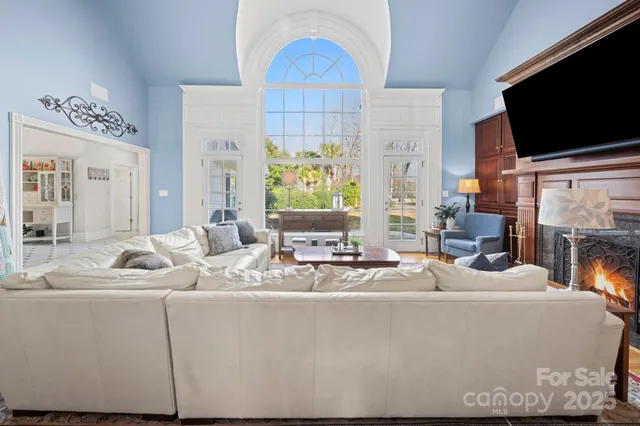 a living room with furniture and a dining table with wooden floor