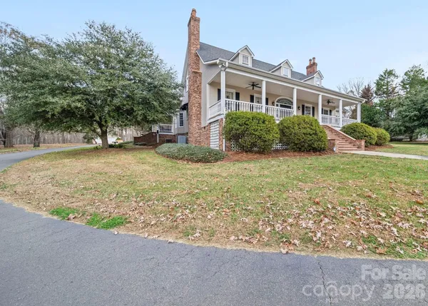 a view of a house with a yard and large tree