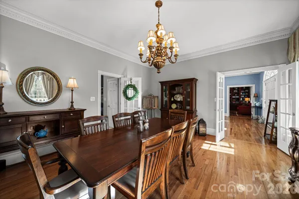 a dining room with furniture a chandelier and wooden floor