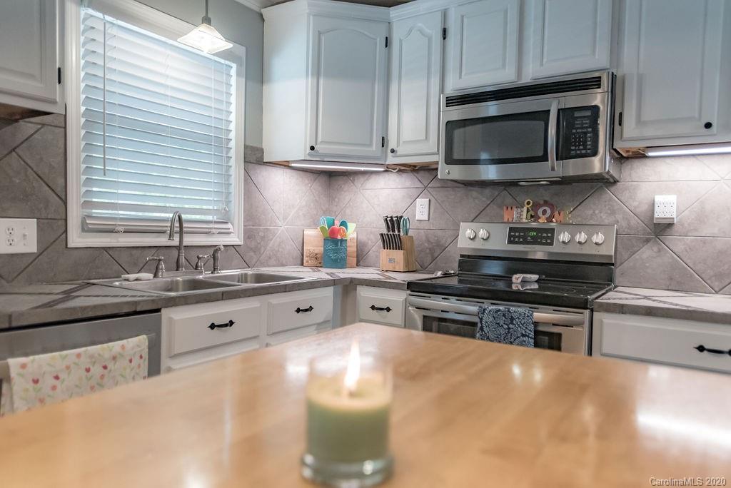 2519 Old Camden Road Monroe, NC 28110 - Photo 12 of 42 a kitchen with stainless steel appliances granite countertop a sink stove microwave and cabinets
