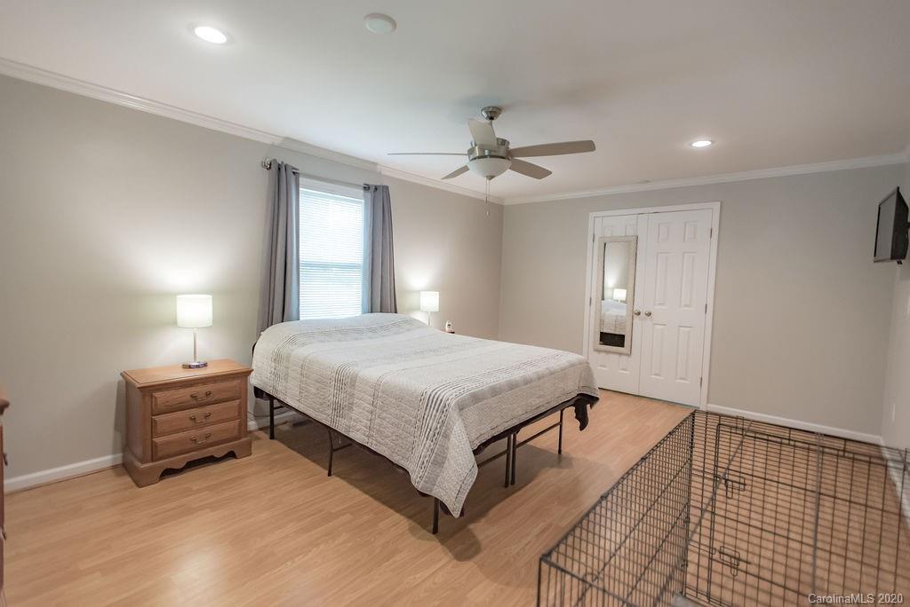 2519 Old Camden Road Monroe, NC 28110 - Photo 25 of 42 a spacious bedroom with a bed and a chandelier