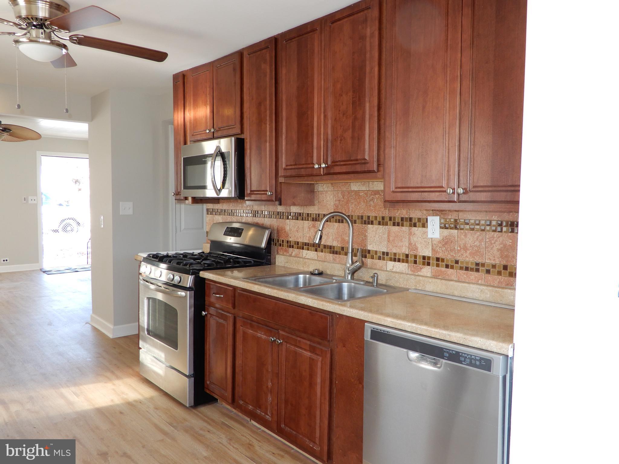 7606 Poplar Road Baltimore, MD 21222 - Photo 8 of 18 a kitchen with stainless steel appliances granite countertop a sink stove and microwave