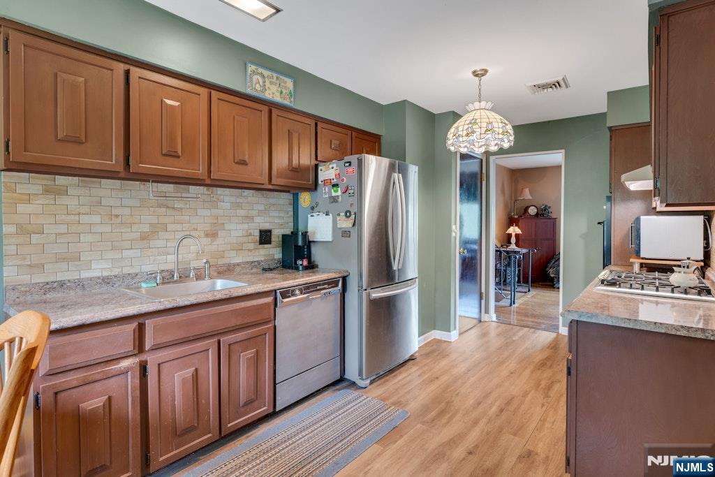 185 Ratzer Road Wayne, NJ 07470 - Photo 16 of 36 a kitchen with stainless steel appliances granite countertop cabinets a refrigerator a sink dishwasher a stove with wooden cabinets and floor