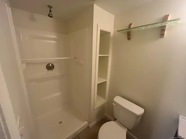 a bathroom with a toilet and a shower