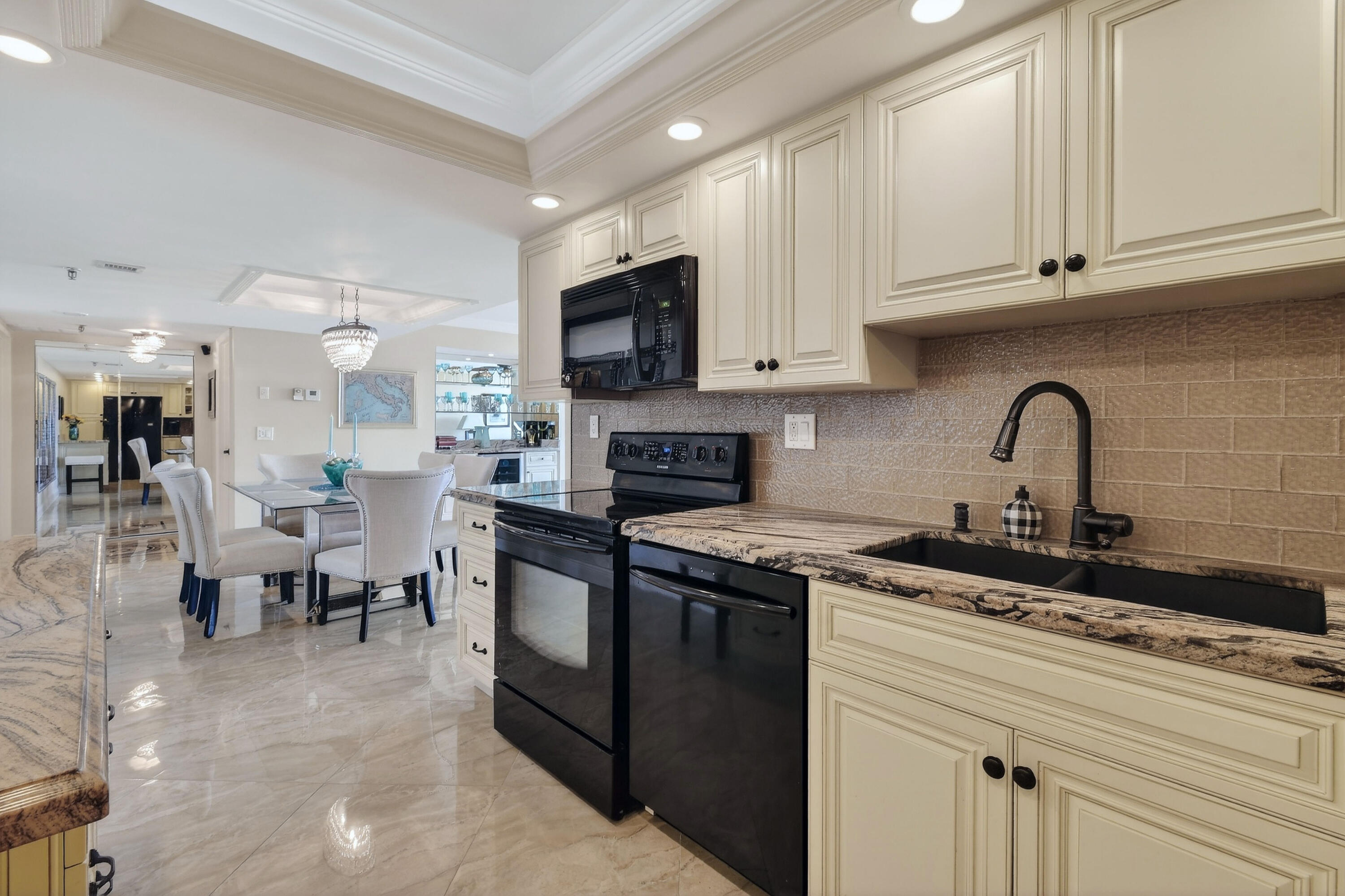 1300 Florida A1A, Unit 320 Jupiter, FL 33477 - Photo 19 of 92 a kitchen with stainless steel appliances granite countertop a sink a stove top oven a dining table and chairs