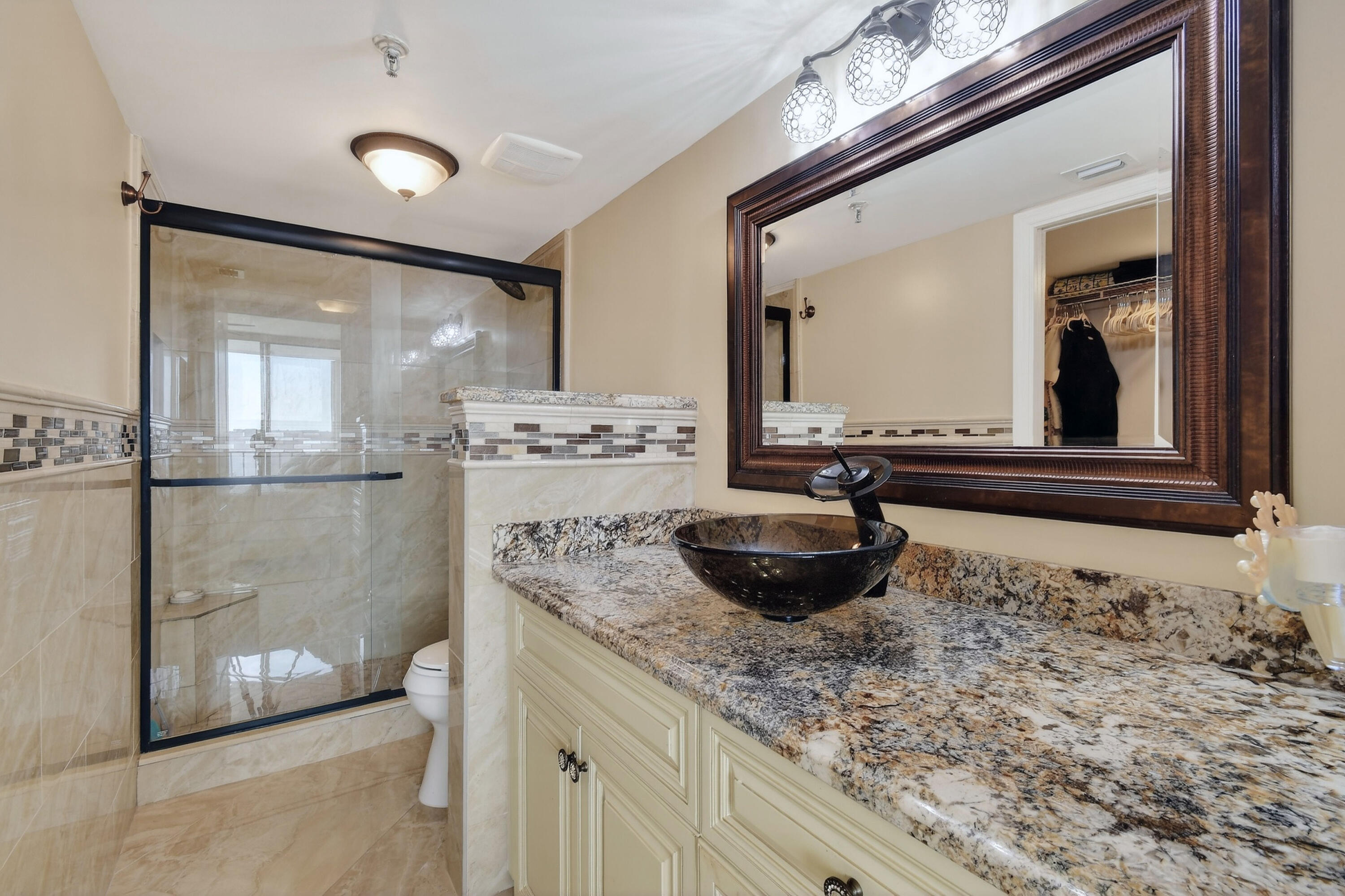 1300 Florida A1A, Unit 320 Jupiter, FL 33477 - Photo 33 of 92 a bathroom with a granite countertop sink a mirror and shower