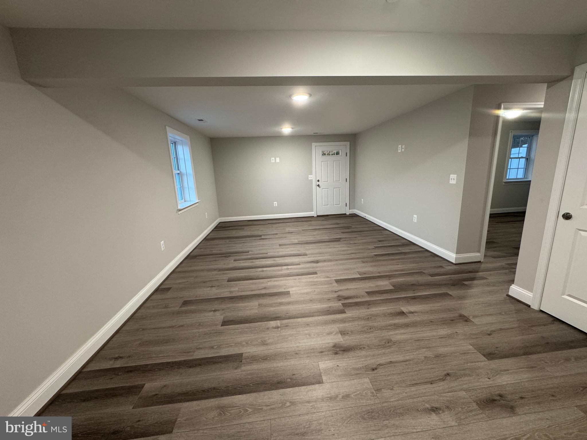 1103 Llano Drive, Unit B La Plata, MD 20646 - Photo 7 of 13 an empty room with wooden floor and windows