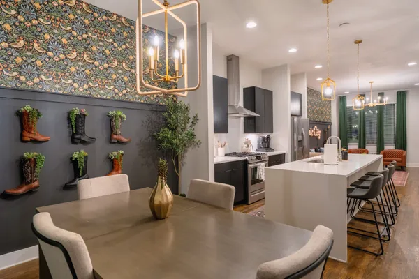 a kitchen with stainless steel appliances kitchen island granite countertop a dining table chairs and granite counter tops
