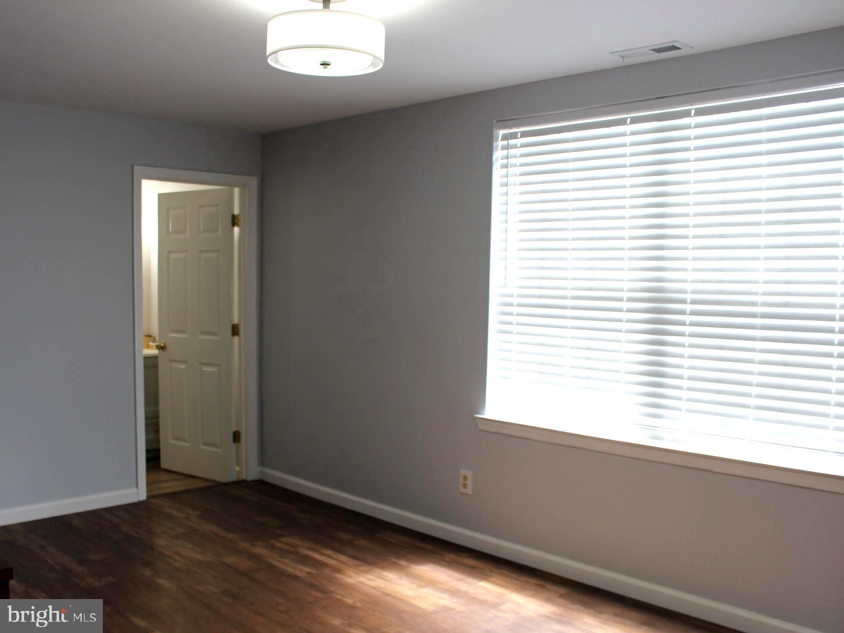 1643 Oldtown Road Edgewater, MD 21037 - Photo 7 of 8 an empty room with wooden floor and windows