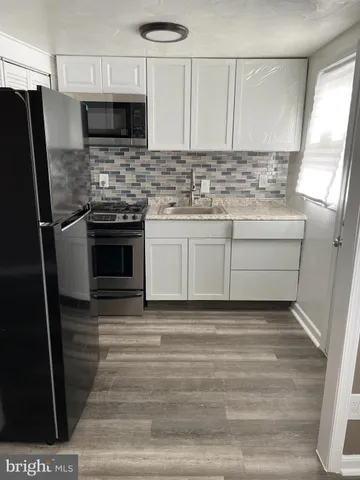 a kitchen with stainless steel appliances kitchen island granite countertop a stove microwave and refrigerator