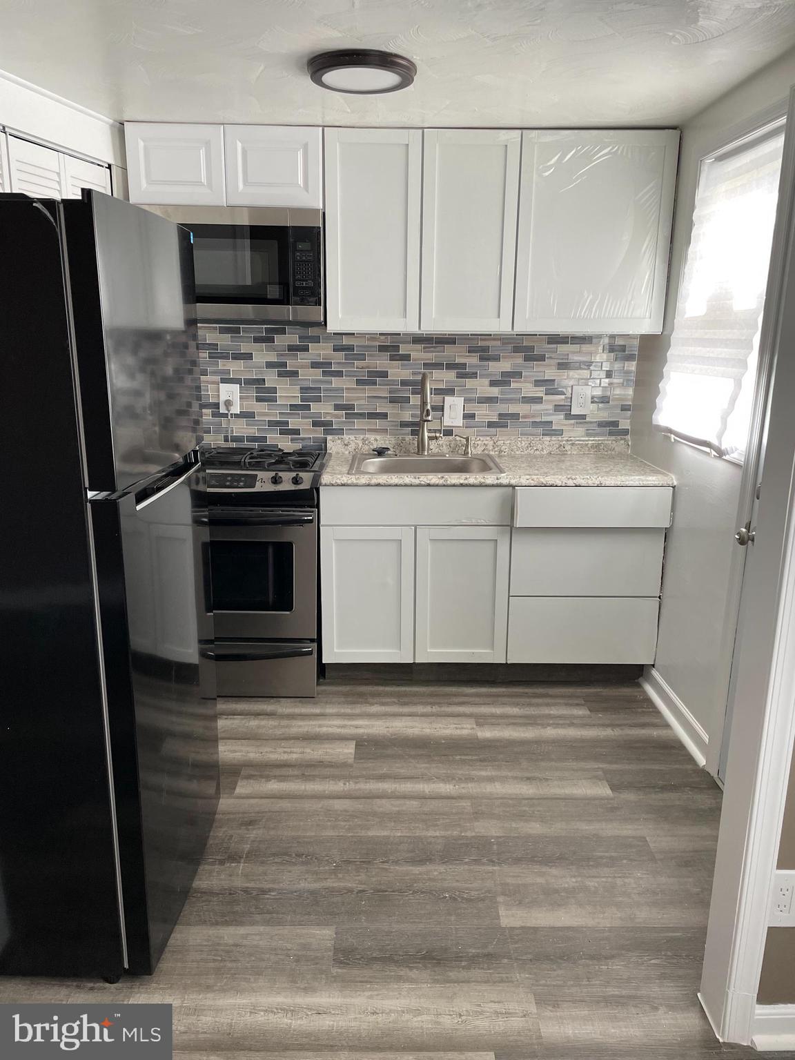 2607 Colebrooke Drive, Unit 21 Temple Hills, MD 20748 - Photo 4 of 9 a kitchen with stainless steel appliances kitchen island granite countertop a stove microwave and refrigerator