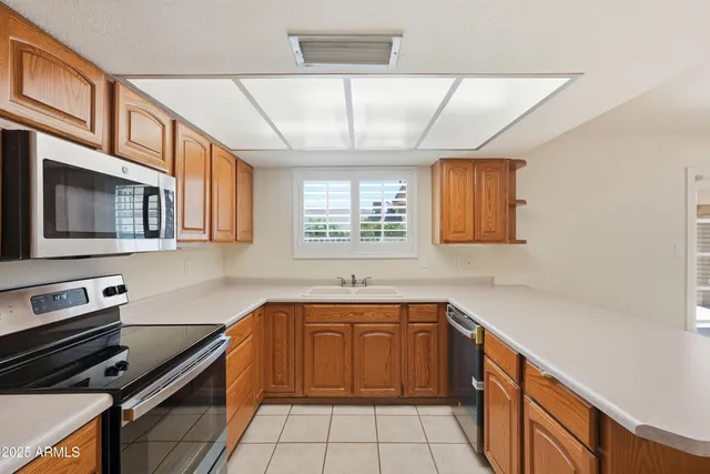 a kitchen with stainless steel appliances granite countertop a refrigerator sink and stove