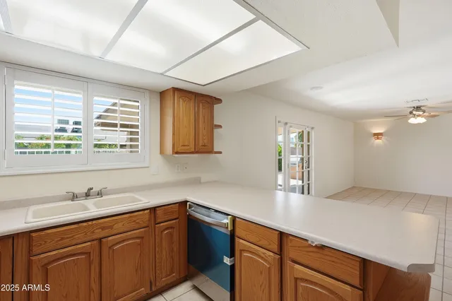 a room with a chandelier and kitchen view