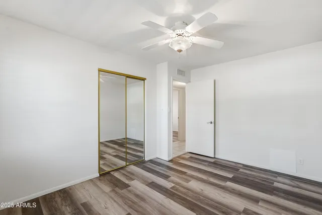 an empty room with windows and fan