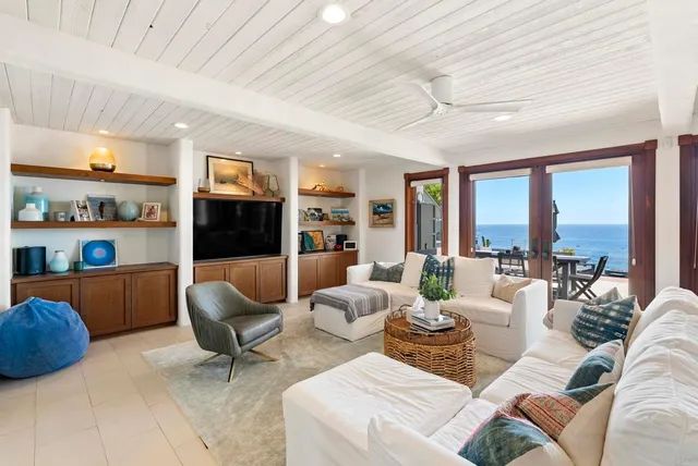 a living room with furniture a large window and a dining table