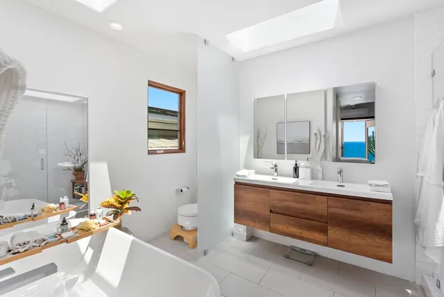 a bathroom with a tub sink and mirror