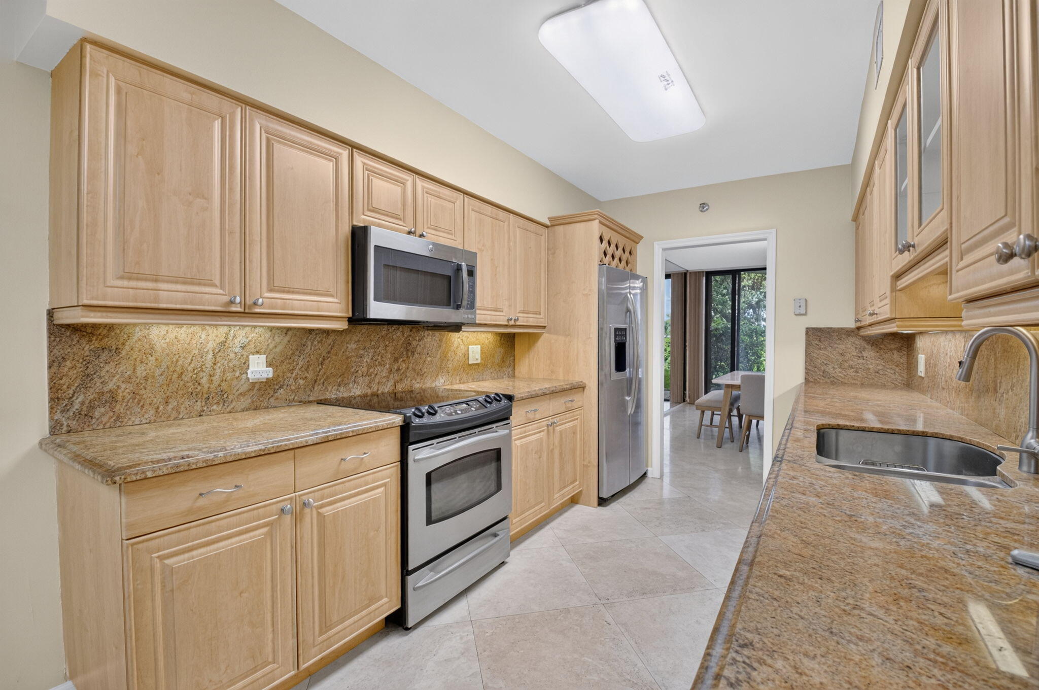 1401 South Ocean Boulevard, Unit 1060 Boca Raton, FL 33432 - Photo 12 of 46 a kitchen with stainless steel appliances granite countertop a stove top oven a sink and a granite counter tops