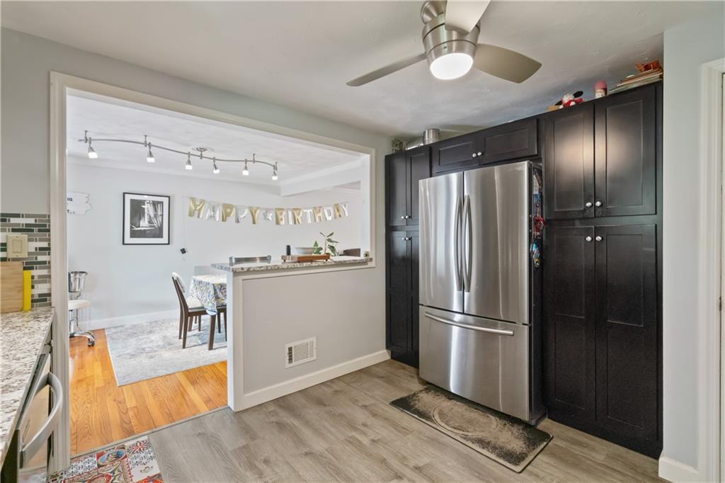 117 Gill Hall Road Clairton, PA 15025 - Photo 13 of 43 Updated kitchen features dark wood cabinetry, granite countertops, stainless steel appliances, tile backsplash, and a gas range. Bright and functional layout opens to dining area.