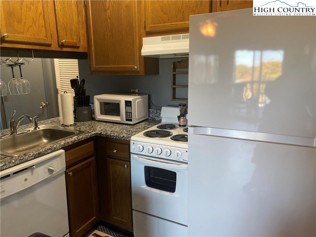 301 Pinnacle Inn Road, Unit 1306 Beech Mountain, NC 28604 - Photo 12 of 19 a kitchen with granite countertop a stove and a sink