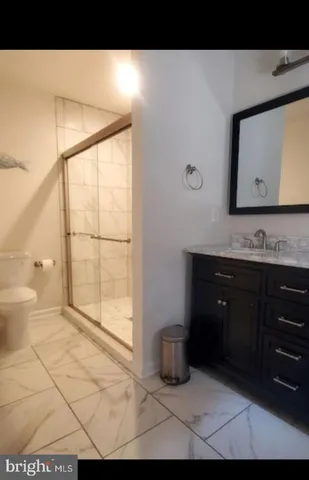 a bathroom with a tub sink vanity and a toilet