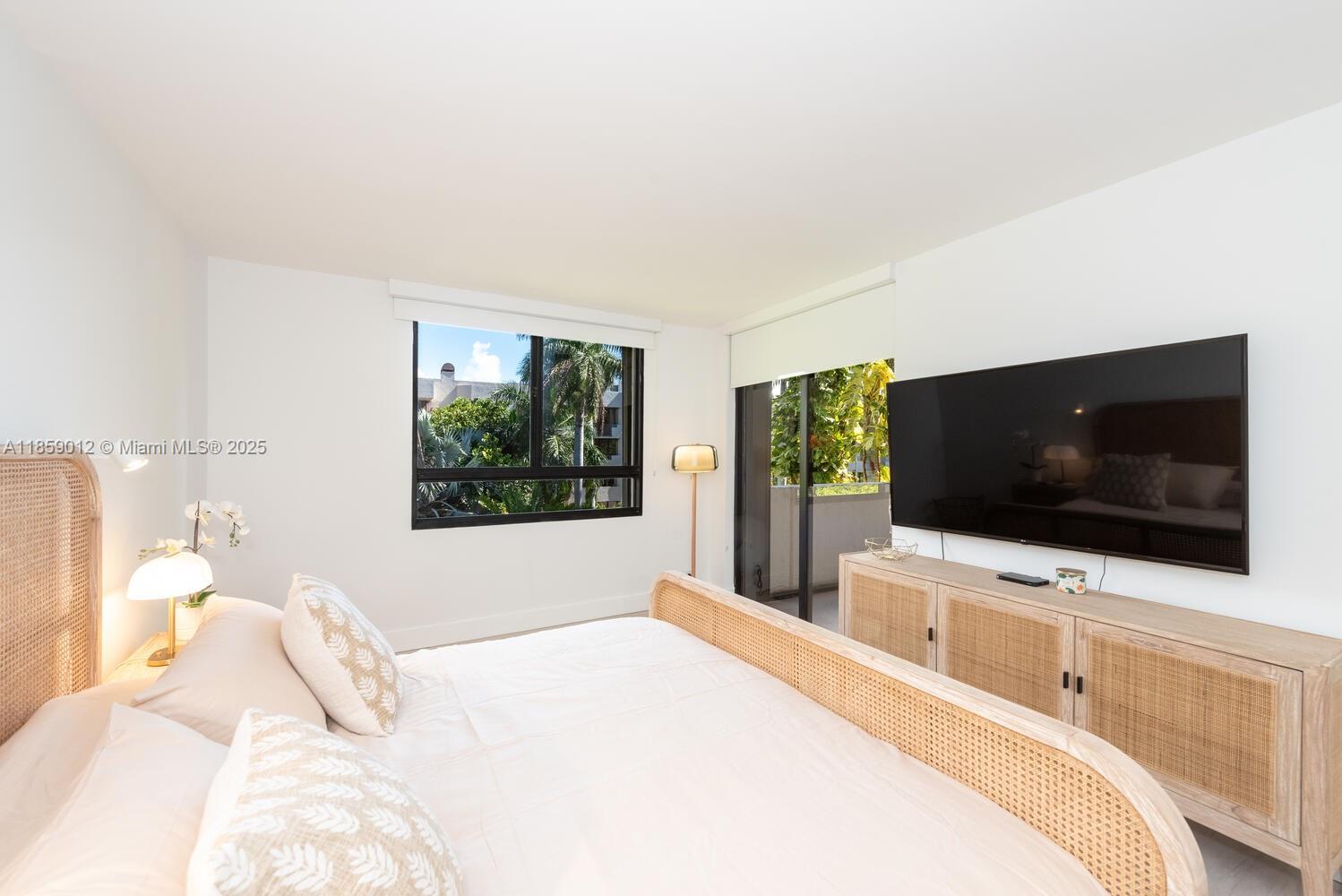 181 Crandon Boulevard, Unit 306 Key Biscayne, FL 33149 - Photo 11 of 25 a bedroom with a flat screen tv and a bed