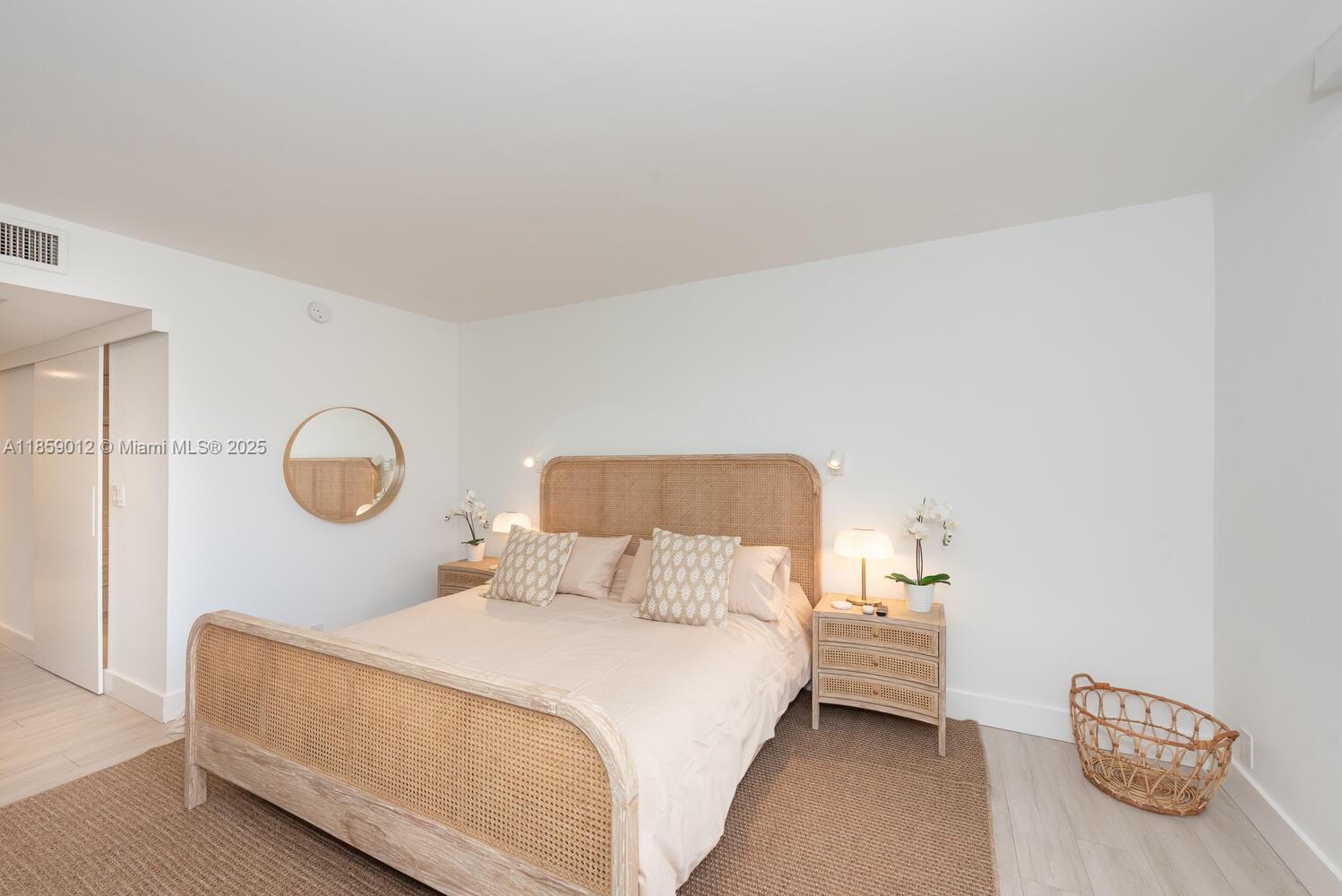 181 Crandon Boulevard, Unit 306 Key Biscayne, FL 33149 - Photo 12 of 25 a bedroom with a bed and a chandelier