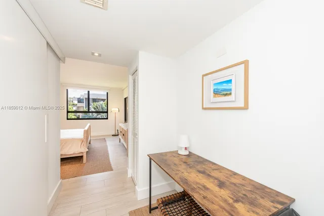 a view of a hallway with bathroom and wooden floor